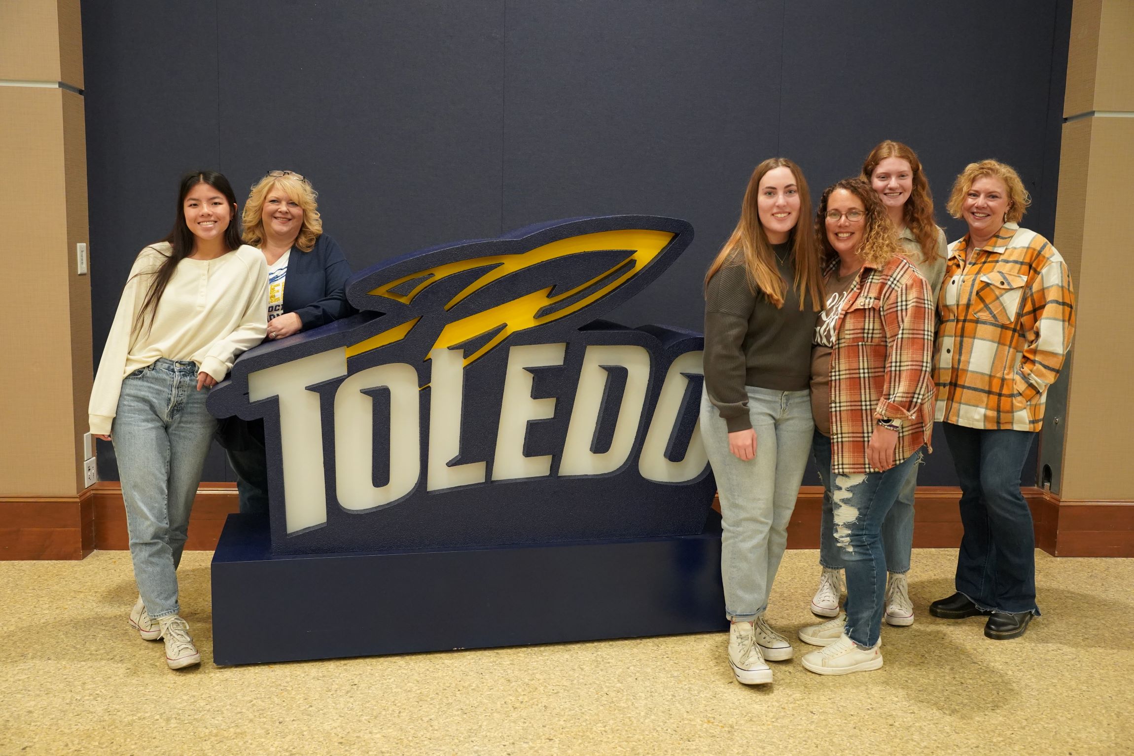 Group of Rocket moms posing for a photo with their Rocket student during Mom's Weekend